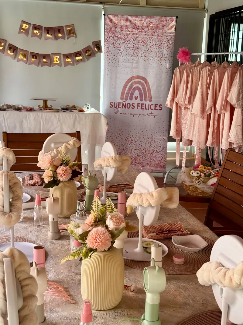 Mesa Glow Spa preparada con espejos, vinchas, flores y el banner de Sueños Felices